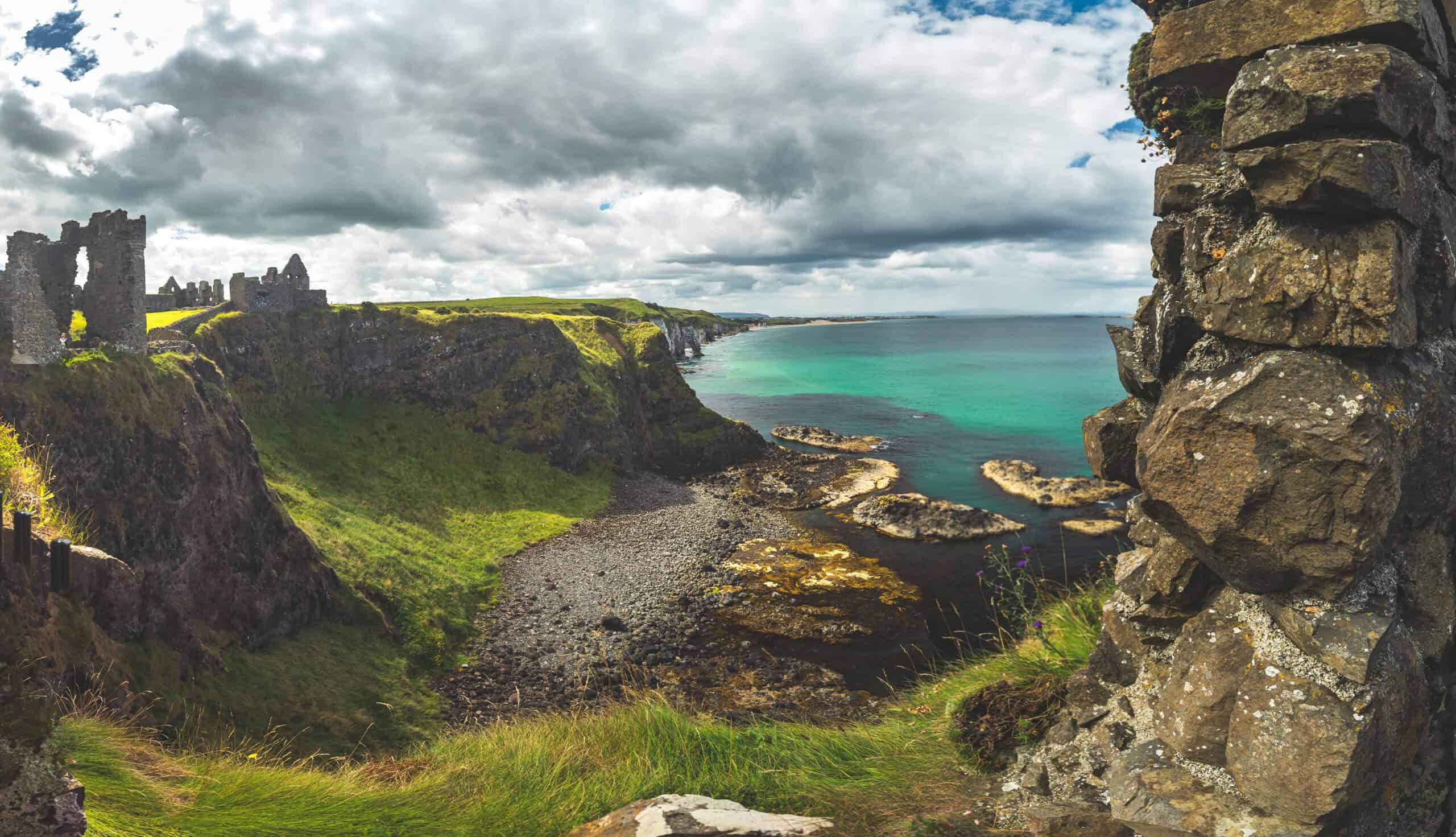 Ruinen einer Burg auf einer grünen Klippe mit Blick auf das Meer in Irland.