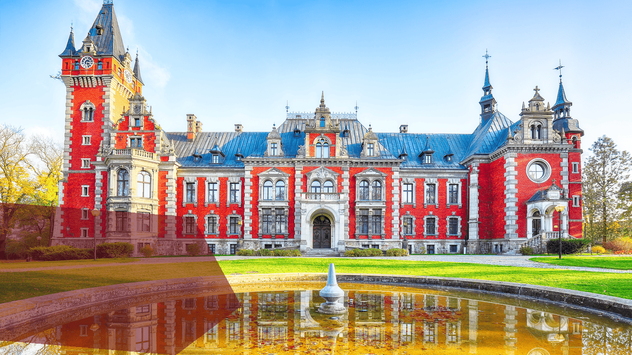 Rotes Schloss mit Turm und Brunnen im Herbst